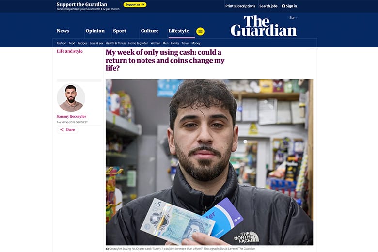 Mann h&auml;lt Bargeld im Laden hoch.